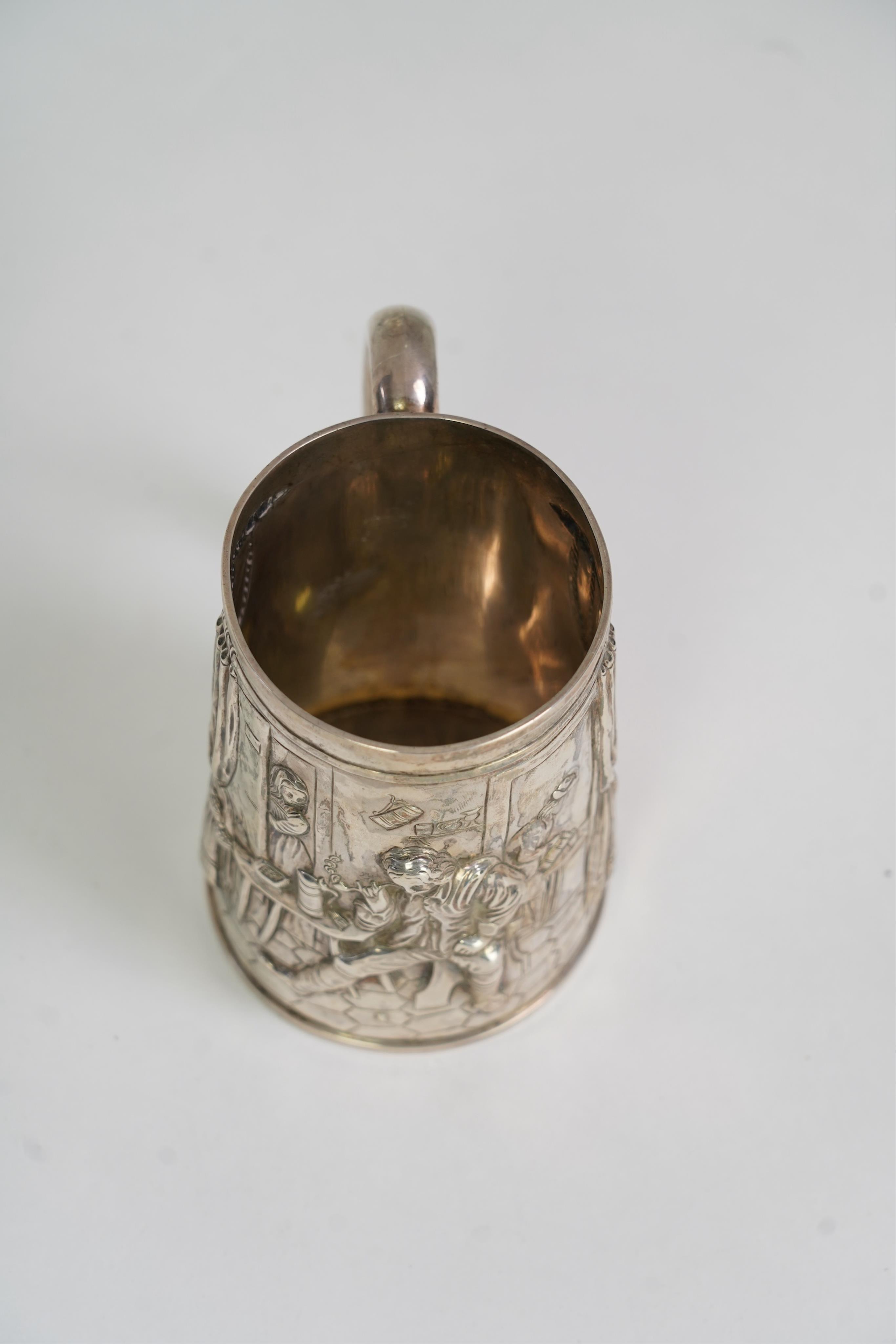 A Victorian silver mug, embossed with interior scene and imbibers, by John Harrison & Co